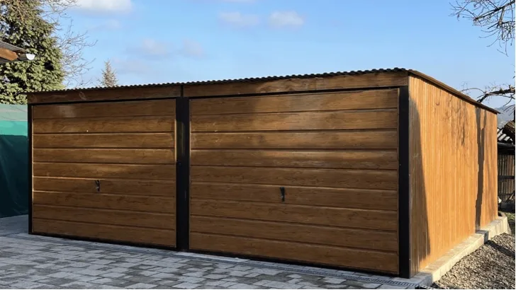 Structure acier double 6 × 5 m décor chêne doré, deux portes basculantes, sur pavés autobloquants